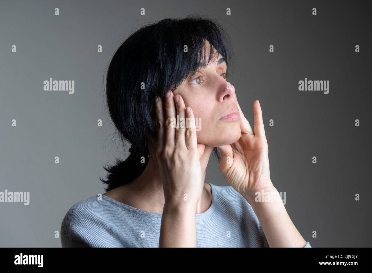 Face yoga, facial gymnastics, daily self care routine. Middle age