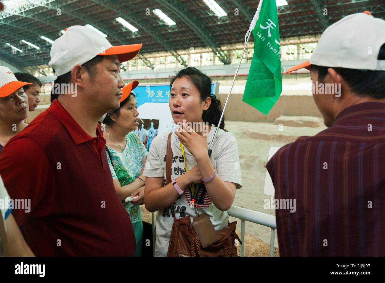 Tour guide with brightly coloured flag leading a party of Chinese tourists visiting / viewing pit 1 at The Terracotta Army at Emperor Qinshihuang's Mausoleum Site Museum in  Xi'An, China. PRC. (125) Stock Photo
