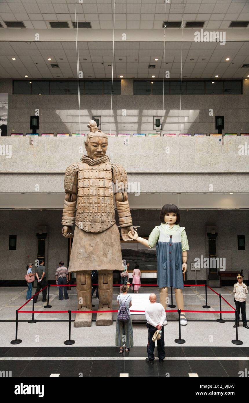 Interior inside of the Relics Hall of the Qin Huang Mausoleum (multiple exhibition centre) part of the Terracotta Army museum complex, contains modern exhibits such as a giant marionette of a terracotta soldier holding the hand of a child puppet, which performed during the 2008 Beijing Olympics ceremony, and ancient artefacts of the armies of Qin Shi Huang, the first emperor of China, in Xi'an, Shanxi. China. PRC. (125) Stock Photo