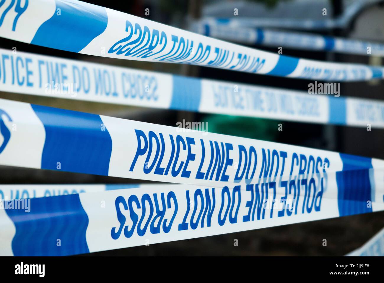 Police Line Do Not Cross tape barrier, typically placed around a crime scene by police officers or scene of crime officer / crimes officers. UK.(131) Stock Photo