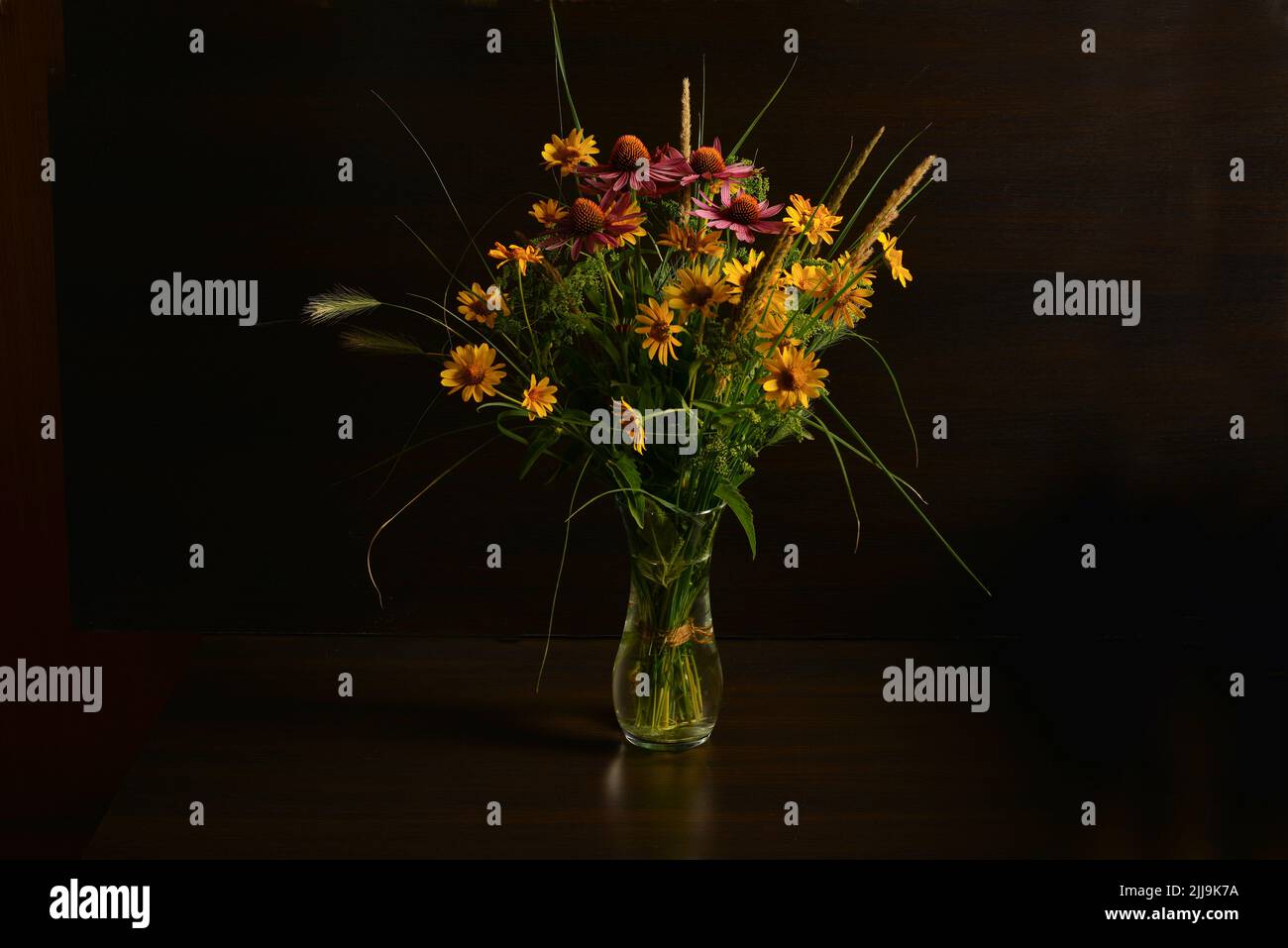 A bouquet of flowers collected in the wild in a simple glass vase ...