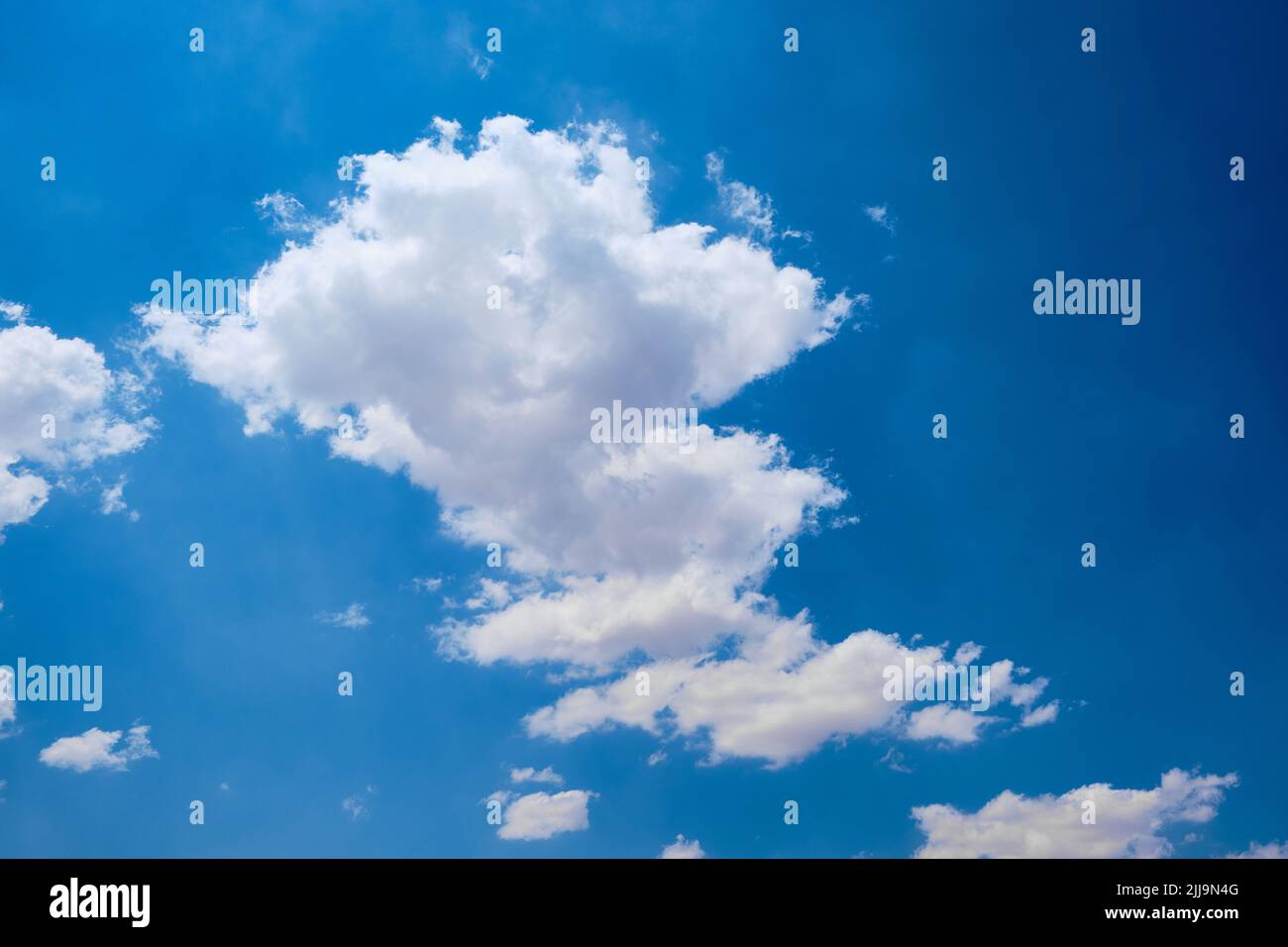 Cumulus clouds against bright blue sky Stock Photo
