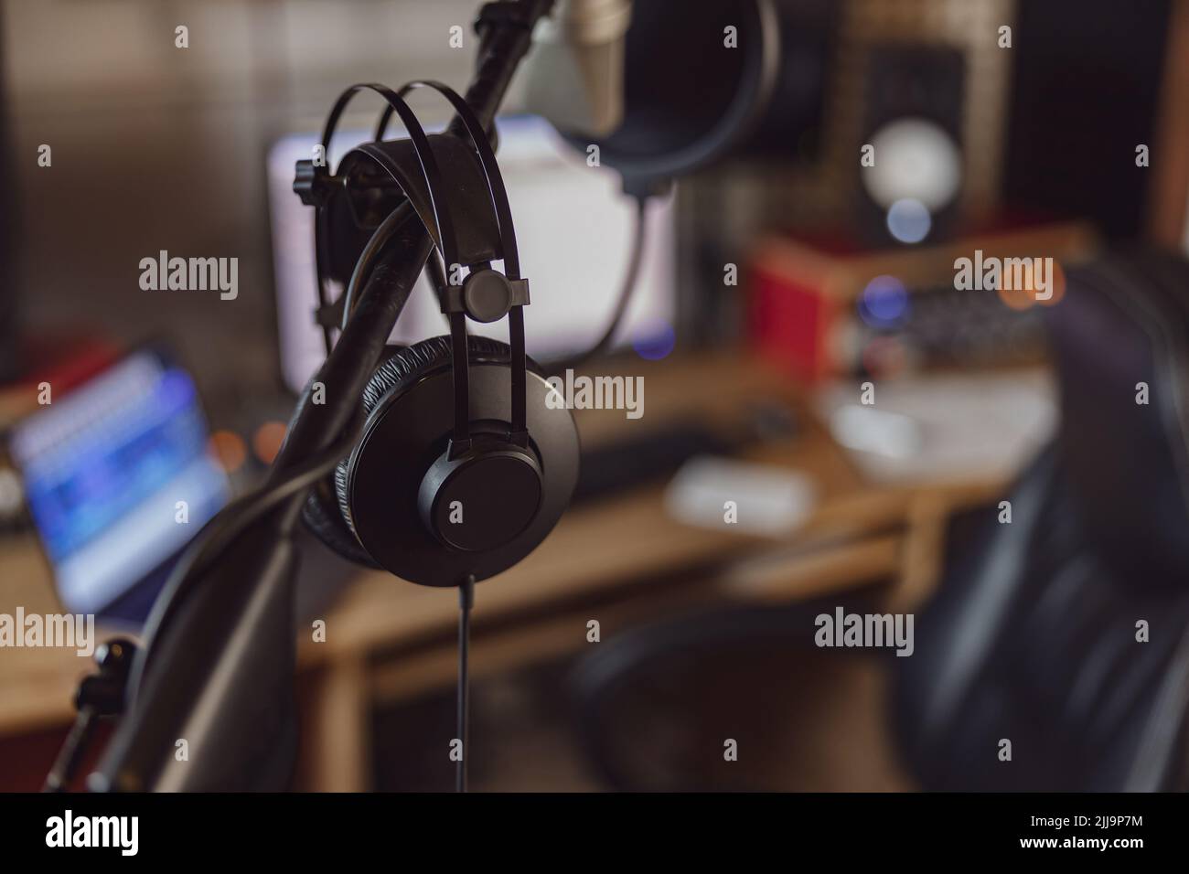 Professional microphone and headphones in the workplace for broadcasting and music rehearsal space. Sound record studio Stock Photo