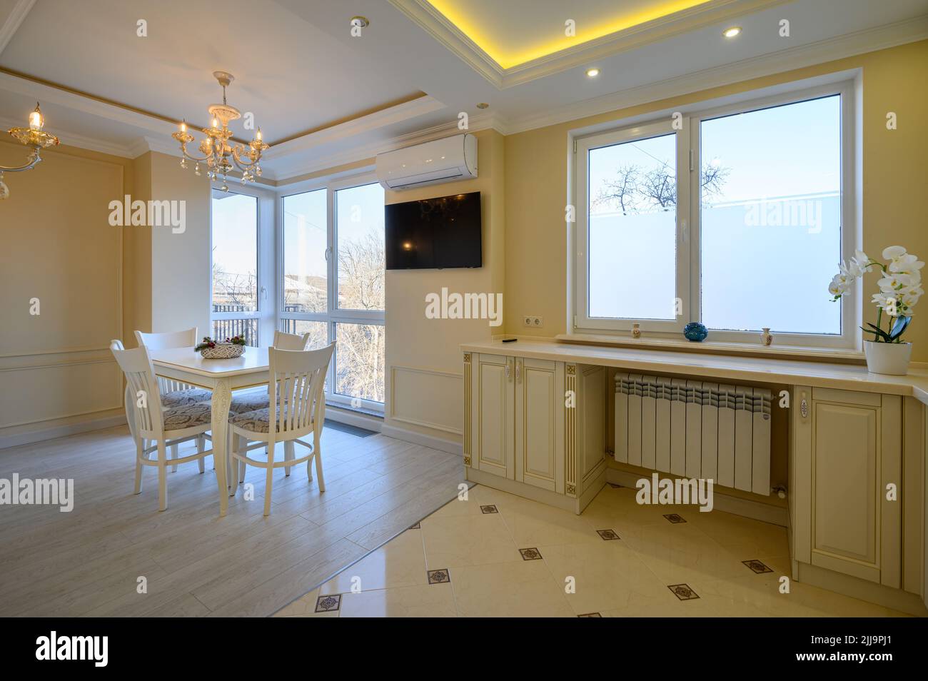 Classic white and beige large kitchen with dining table in studio