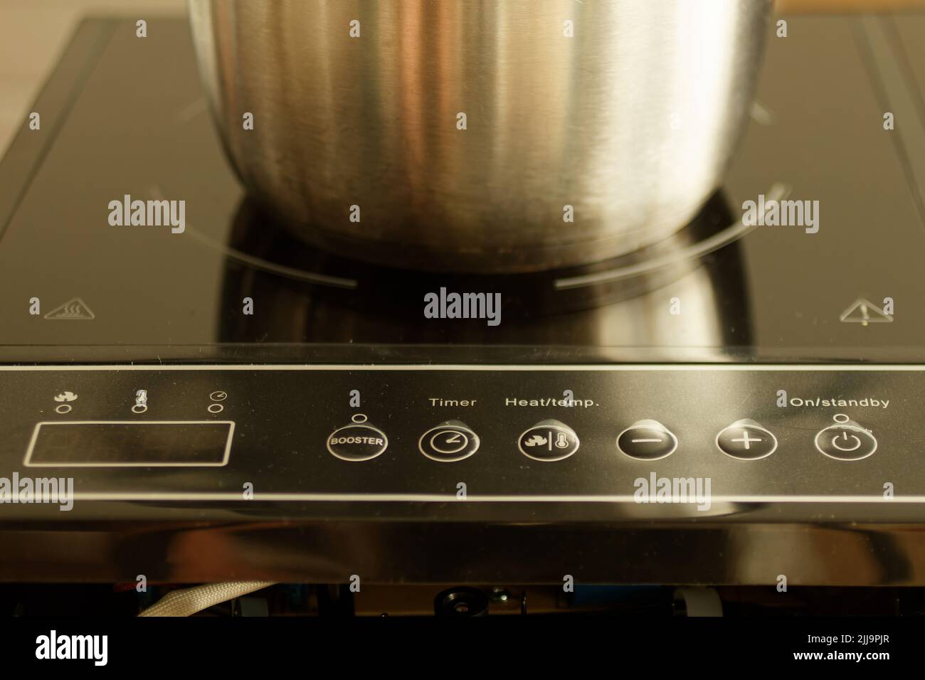 Stainless steel pot on the heating element of an induction cooker Stock