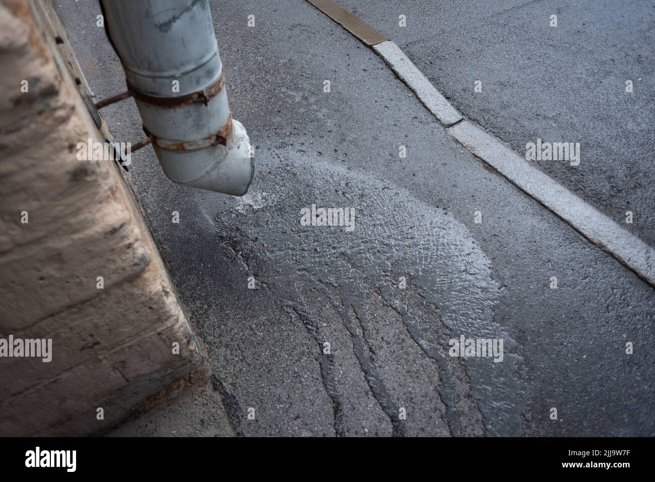 Rainy weather concept. Drainpipe through which water flows from rain that has just begun. Stock Photo