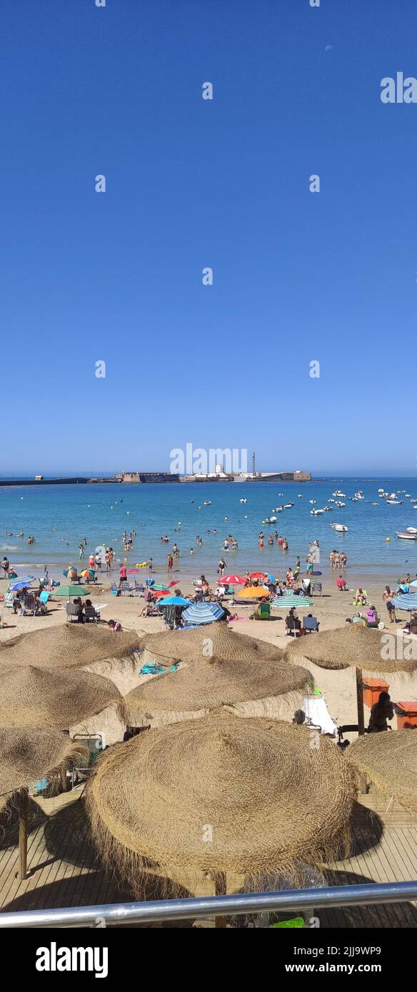 Cadiz, Spain July 20, 2022: Umbrellas and sunbathers at La Caleta beach in Cadiz Stock Photo