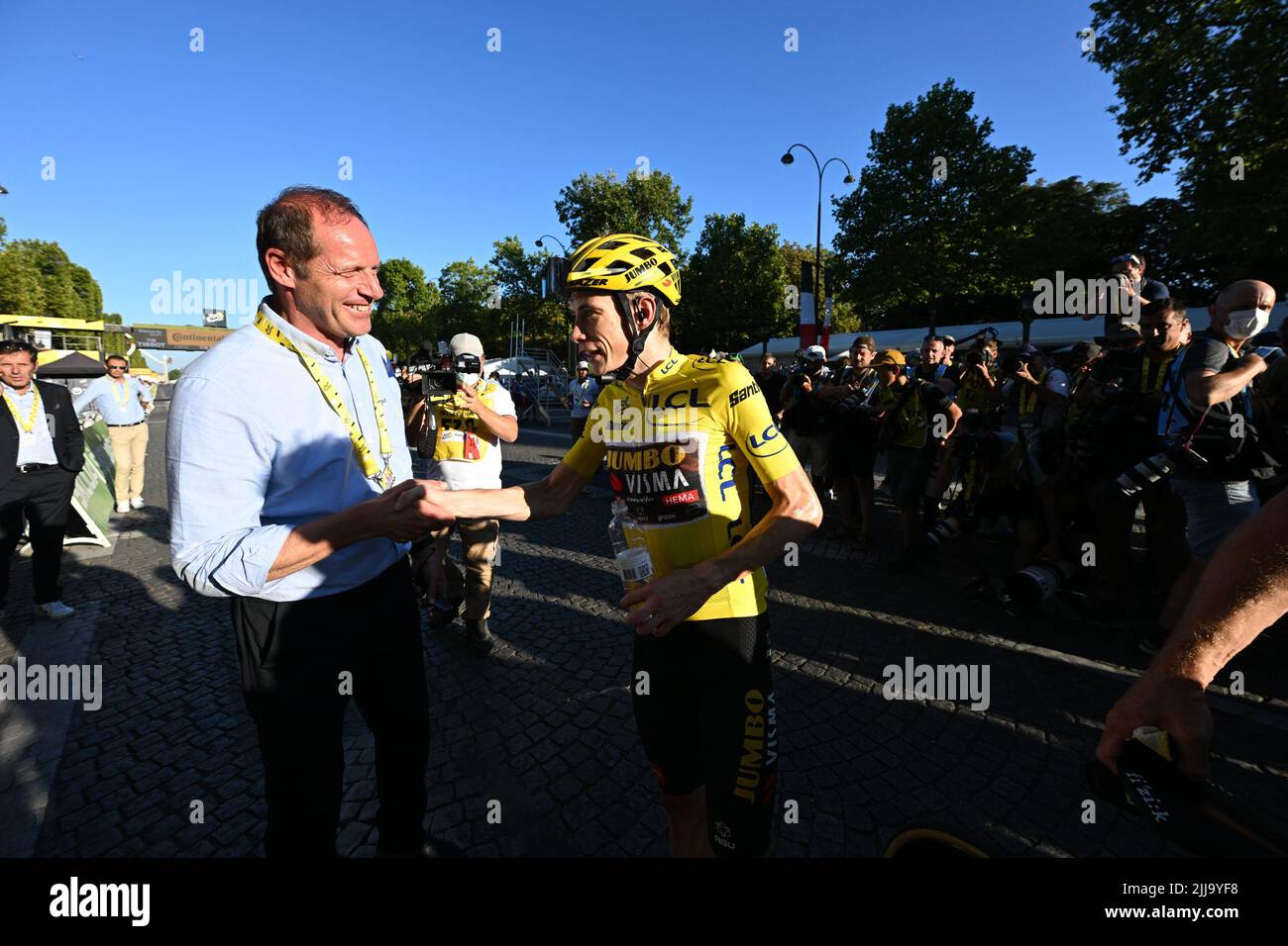 Champs-Elysees, France, 24 July 2022. Christian Prudhomme, cycling director of ASO (Amaury Sport Organisation) and Danish Jonas Vingegaard of Jumbo-Visma wearing the yellow jersey of leader in the overall ranking shake hands after stage 21, the final stage of the Tour de France cycling race, from Paris la Defense Arena to Paris Champs-Elysees, France, on Sunday 24 July 2022. This year's Tour de France takes place from 01 to 24 July 2022. BELGA PHOTO POOL VINCENT KALUT - UK OUT Stock Photo