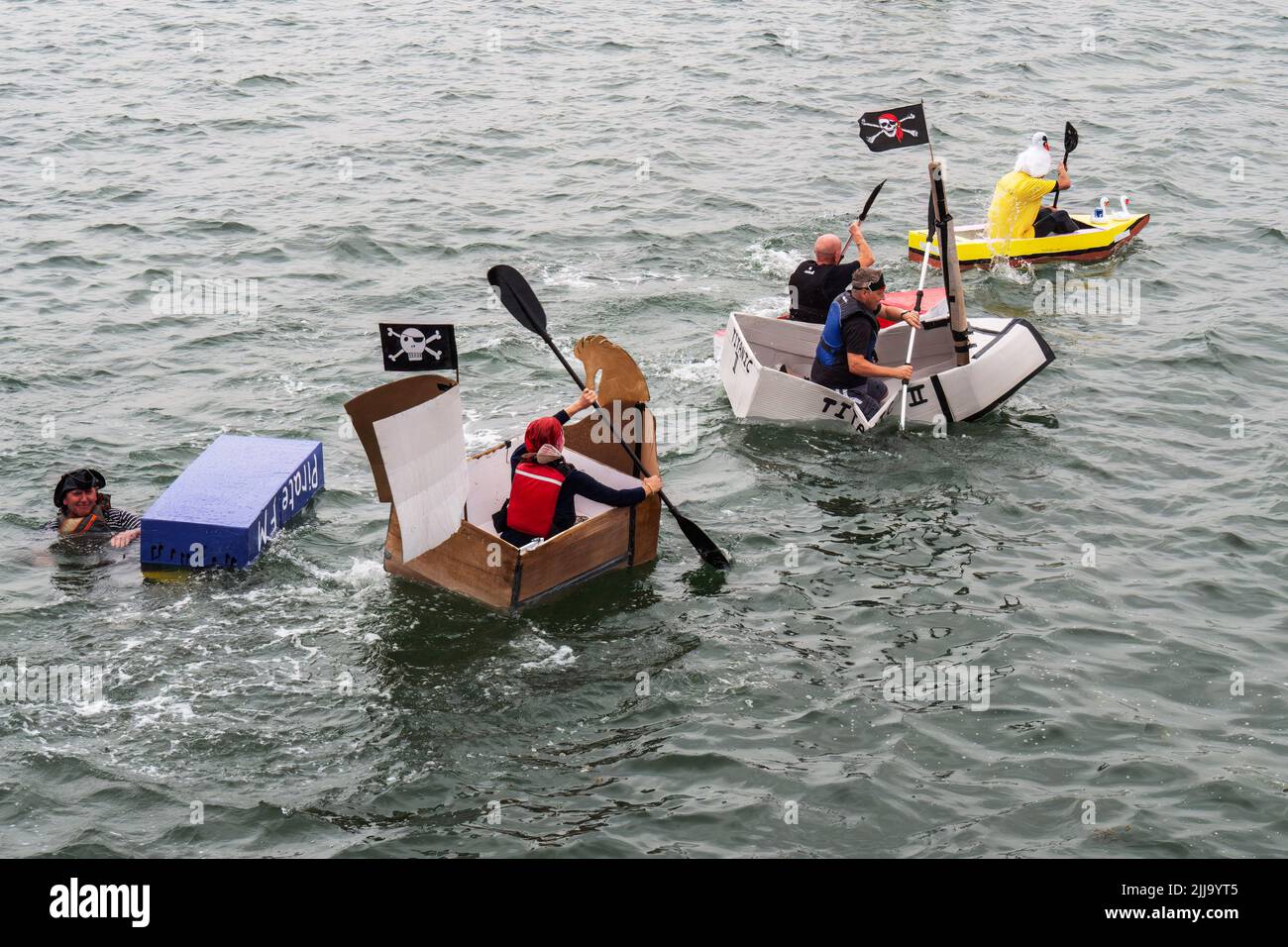 BIDEFORD, DEVON, ENGLAND - JULY 24 2022: Participants in annual Water Festival Cardboard Boat Race, River Torridge. Rainy day. Stock Photo