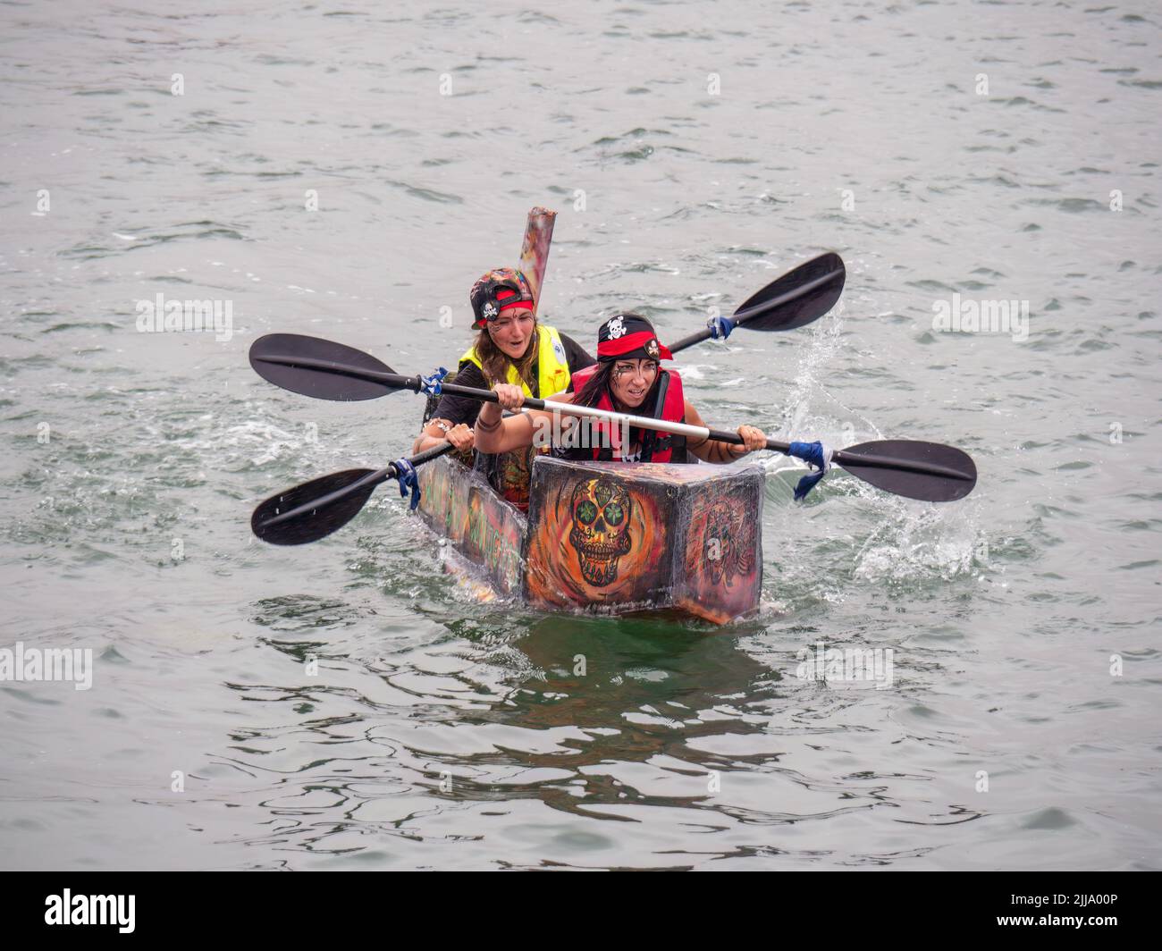 BIDEFORD, DEVON, ENGLAND - JULY 24 2022: Participant in annual Water Festival Cardboard Boat Race, River Torridge. Rainy day. Stock Photo