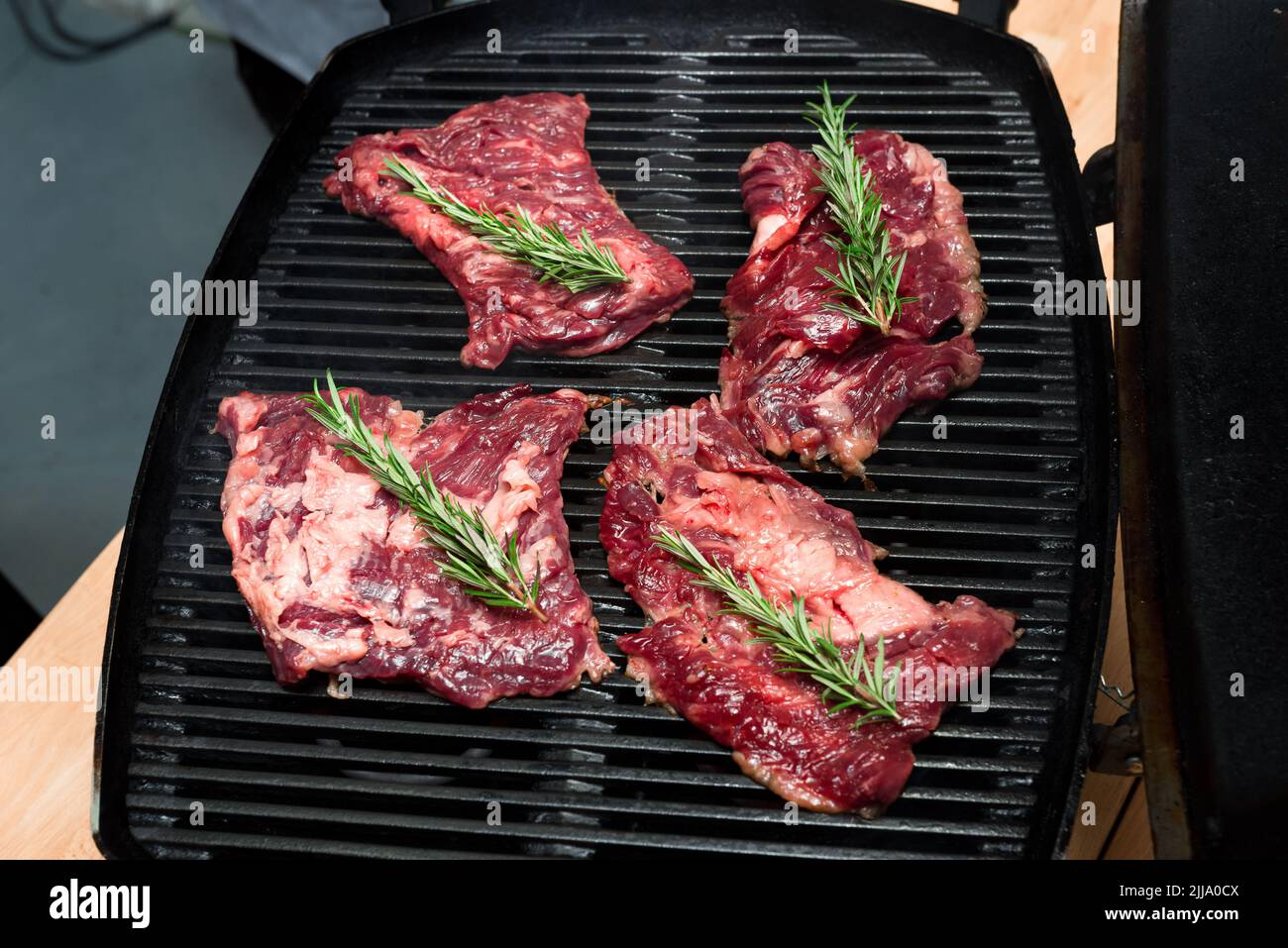 Chunks of beef meat with a branch of rosemary before grilling, raw