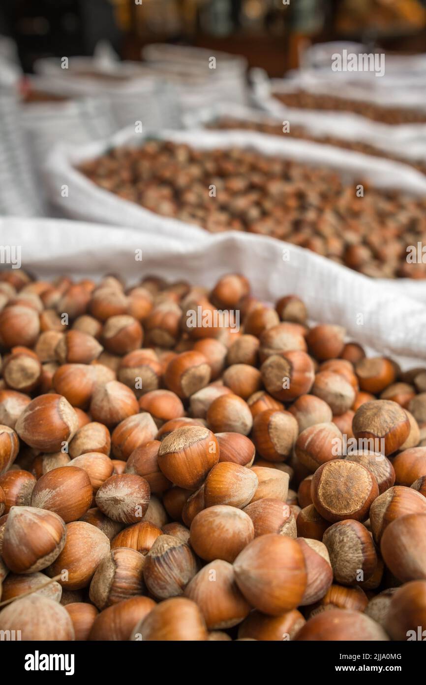 Fresh hazelnuts in shells for sale in outdoor food market. Stock Photo