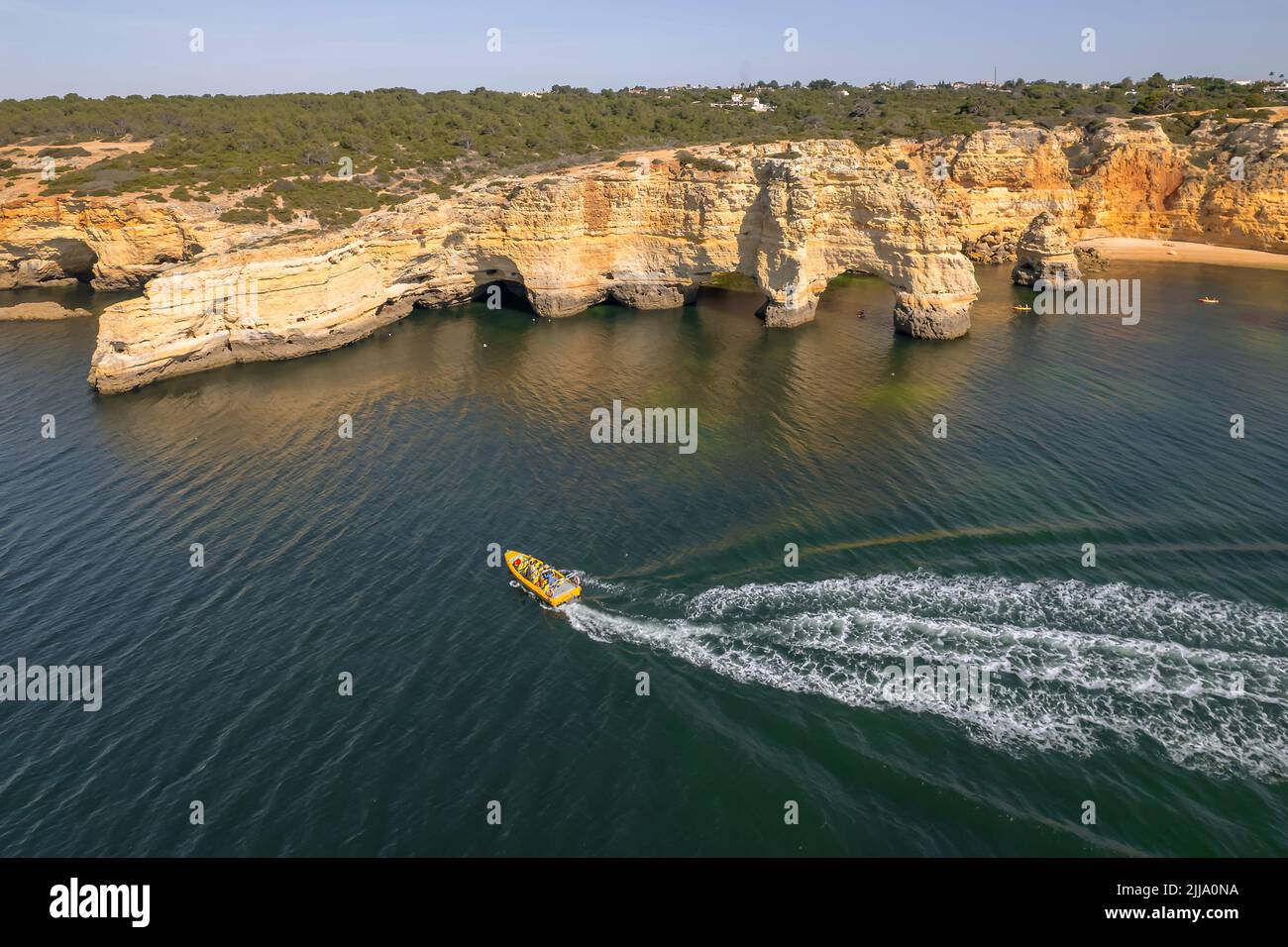 Tourist speed boat riding along a beautiful coast in Algarve province, Portugal Stock Photo