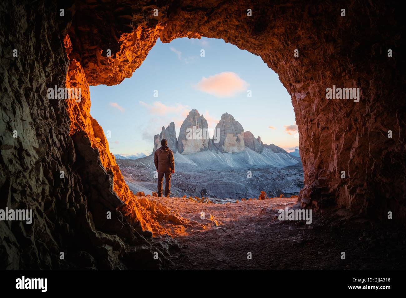 Tre Cime Di Lavaredo peaks in incredible orange sunset light. View from the cave in mountain against Three peaks of Lavaredo, Dolomite Alps, Italy, Europe. Landscape photography Stock Photo