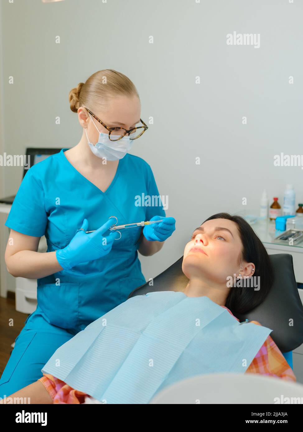 Female dentist with cartridge syringe getting ready to use anesthesia