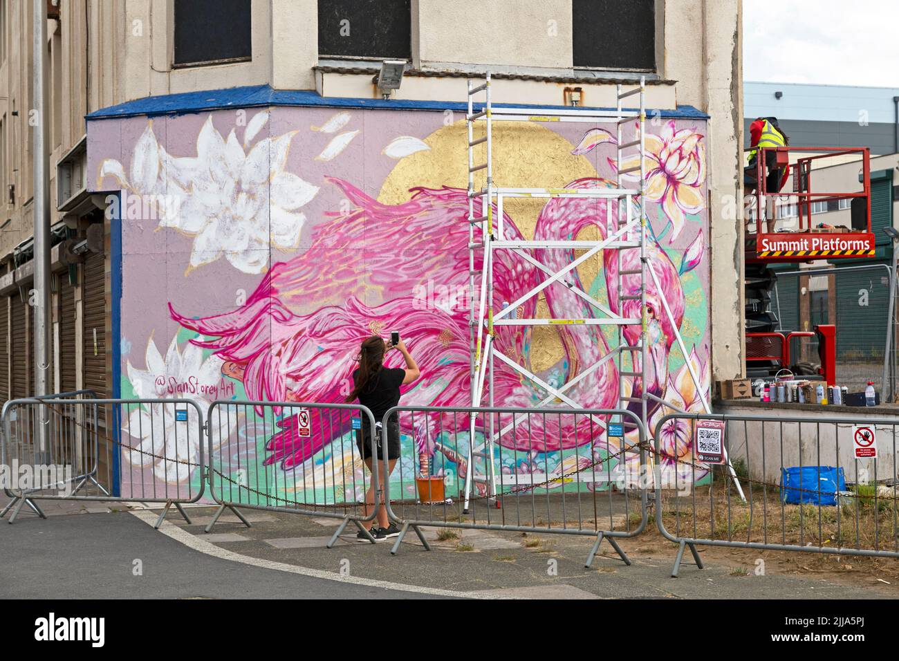 Weston-super-Mare, UK, 24 July 2022: Artist Sian Storey surveys her work on the second day of Weston Wallz 2022. Weston Wallz is an annual event organised by Upfest, Europe’s largest street art festival, in partnership with Culture Weston and Weston-super-Mare Town Council. Stock Photo