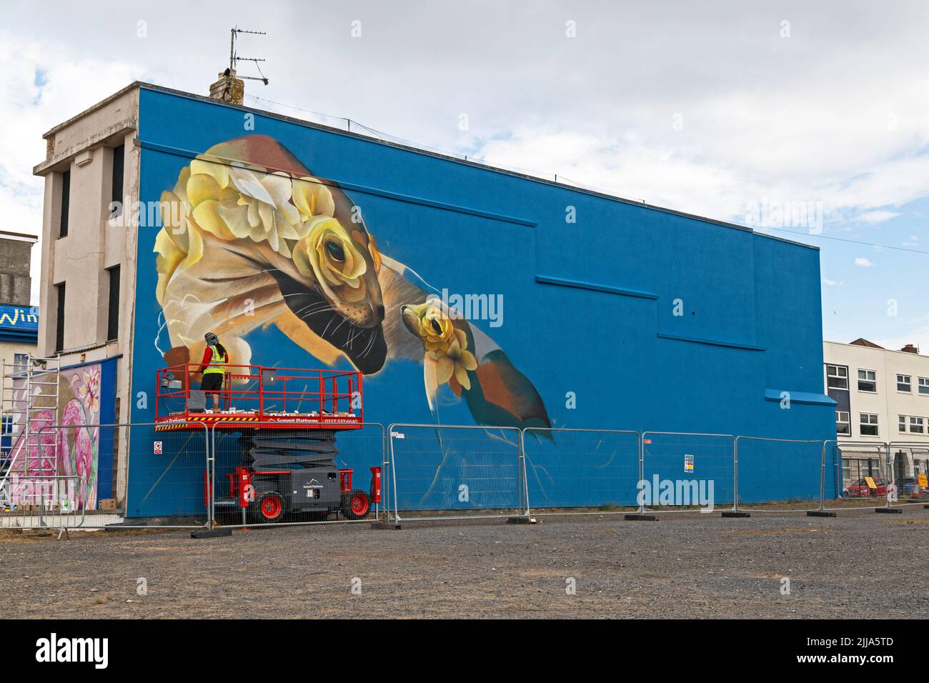 Weston-super-Mare, UK, 24 July 2022: Artist Curtis Hylton at work on the second day of Weston Wallz 2022. Weston Wallz is an annual event organised by Upfest, Europe’s largest street art festival, in partnership with Culture Weston and Weston-super-Mare Town Council. Stock Photo