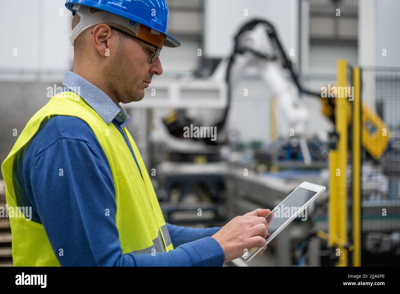 Portrait of engineer adjusting controls with tablet Stock Photo