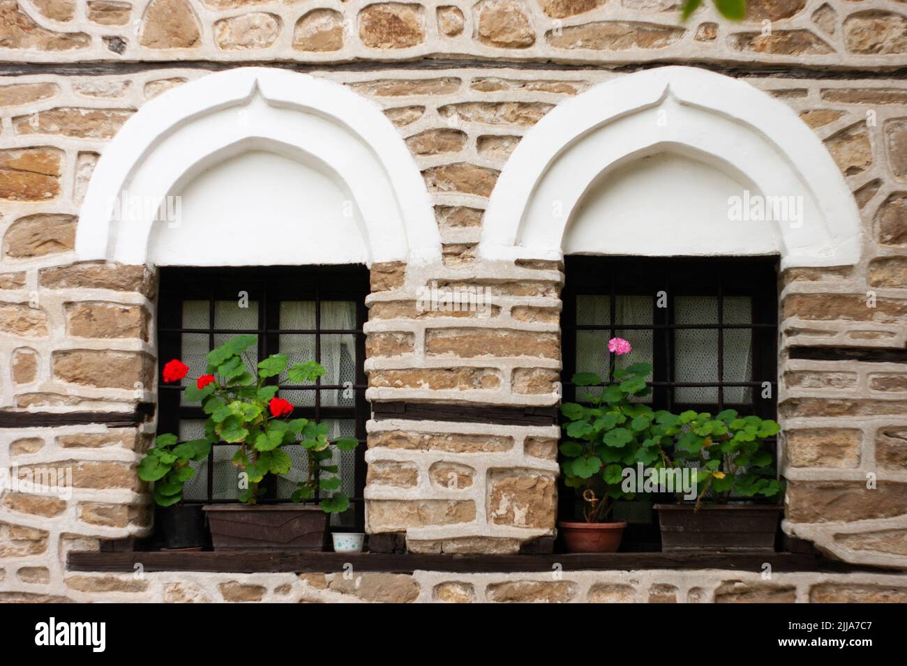 Medieval Architecture window treatment rebuilt in Arbanasi, Bulgaria, site of a 12th century fortress. The stone work was done using found materials. Stock Photo