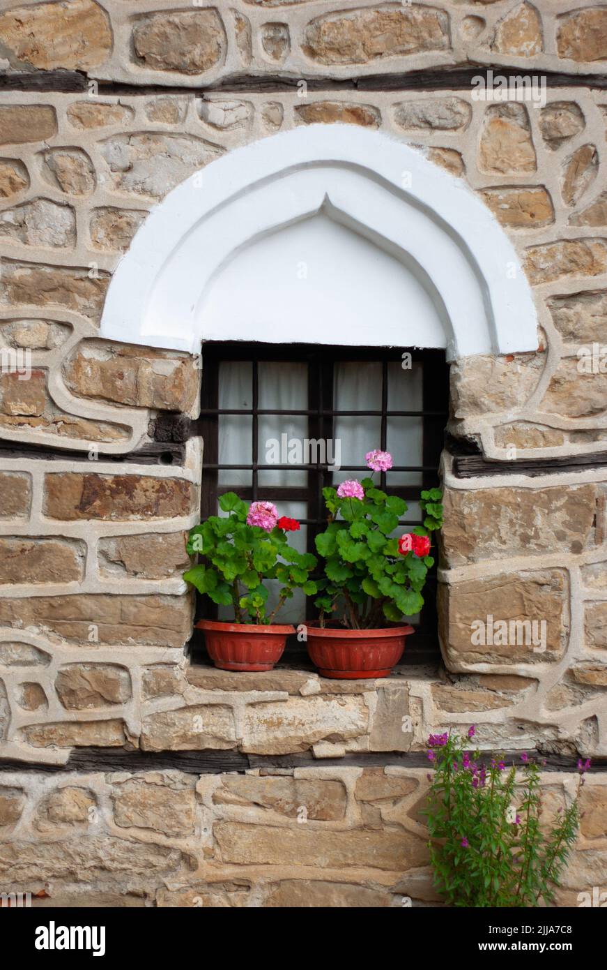 Medieval Architecture window treatment rebuilt in Arbanasi, Bulgaria, site of a 12th century fortress. The stone work was done using found materials. Stock Photo