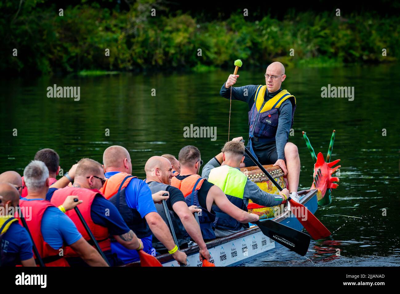 Man in in spectacles banging the drum in a Dragon Boat race Stock Photo