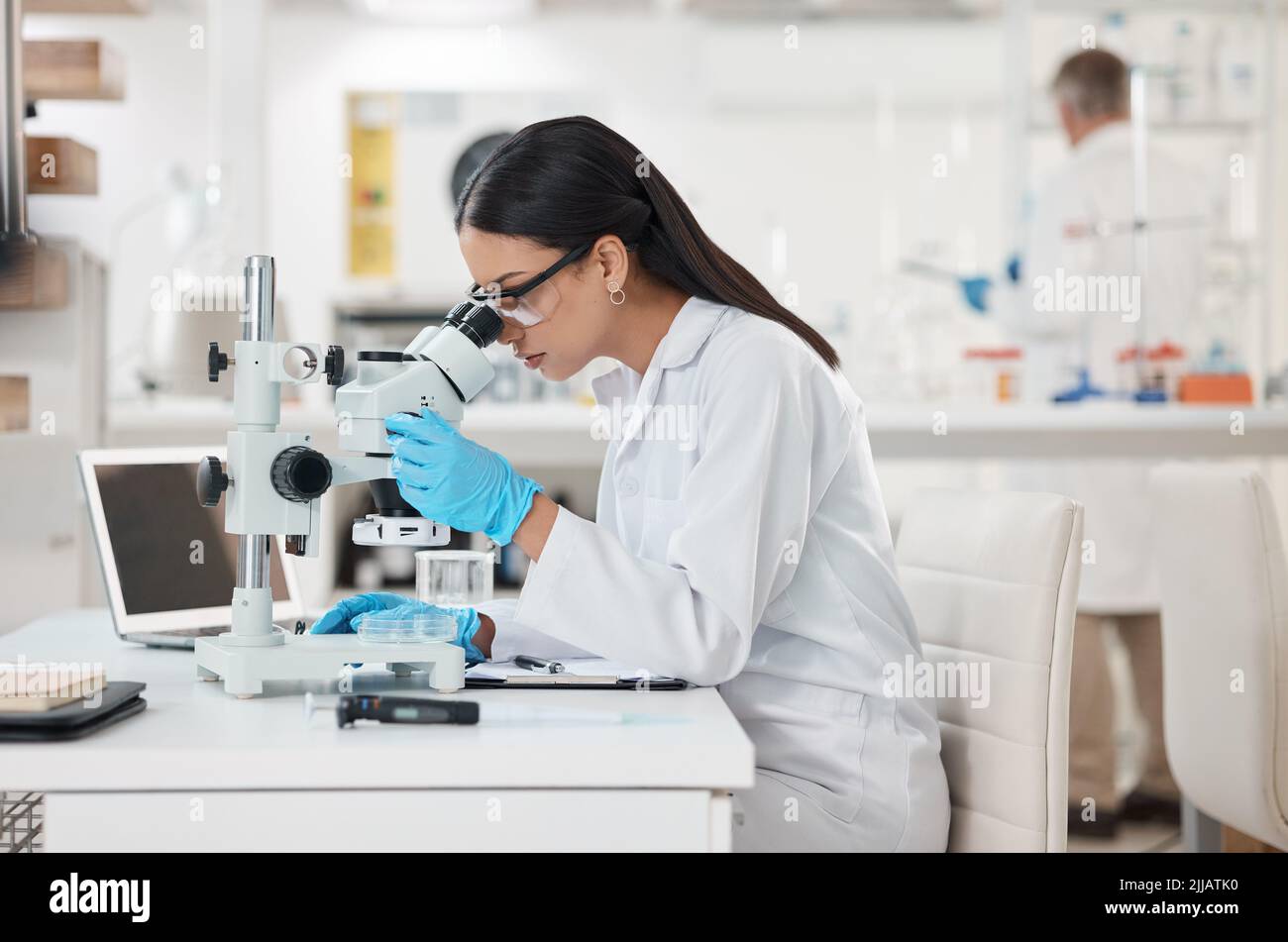 Unpacking a new specimen. a young scientist using a microscope in a lab