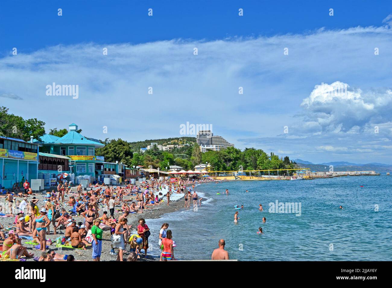 ALUSHTA, CRIMEA, UKRAINE: People on the public pebble beach near Black Sea in Alushta, Ukraine. Alushta is famous Crimean resort. Stock Photo
