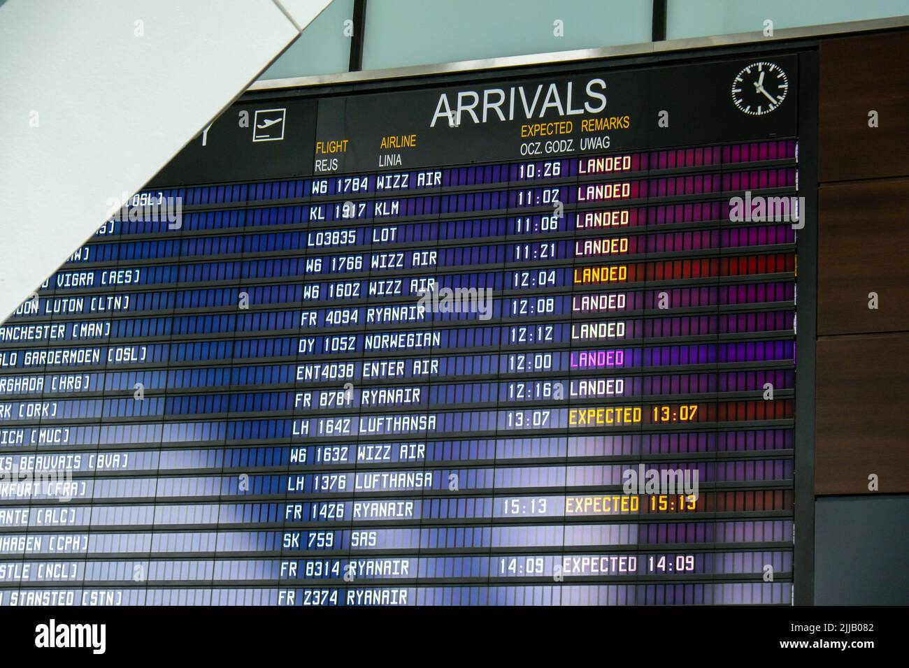 Gdansk Poland - May 2022. Flight information board, checking flights. Tourists at international airport terminal flight timetable. Travel concept Airport Tab showing flights being delayed and canceled  Stock Photo