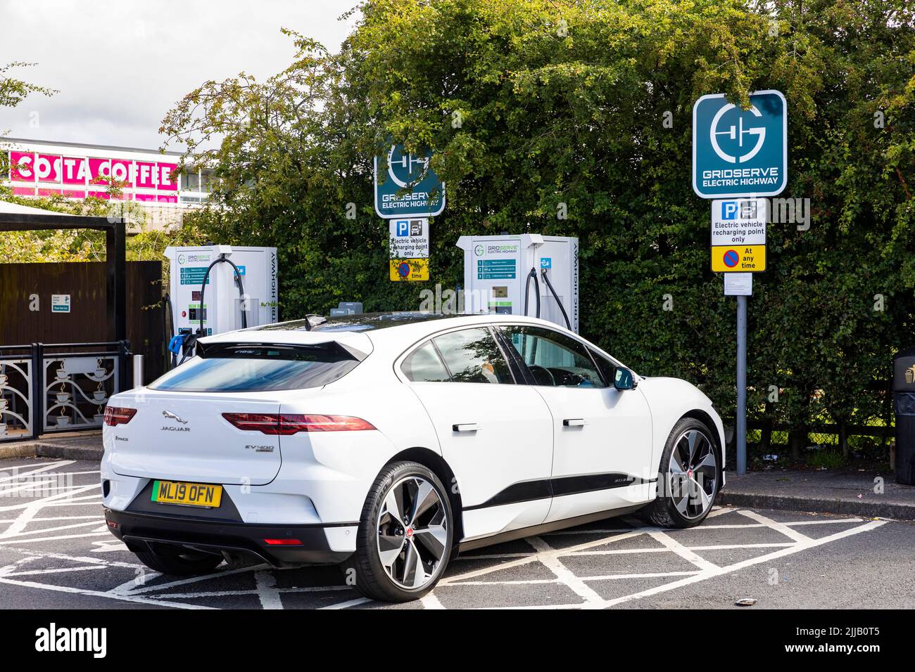 Electric Jaguar Ipace in white being charged at a motorway service