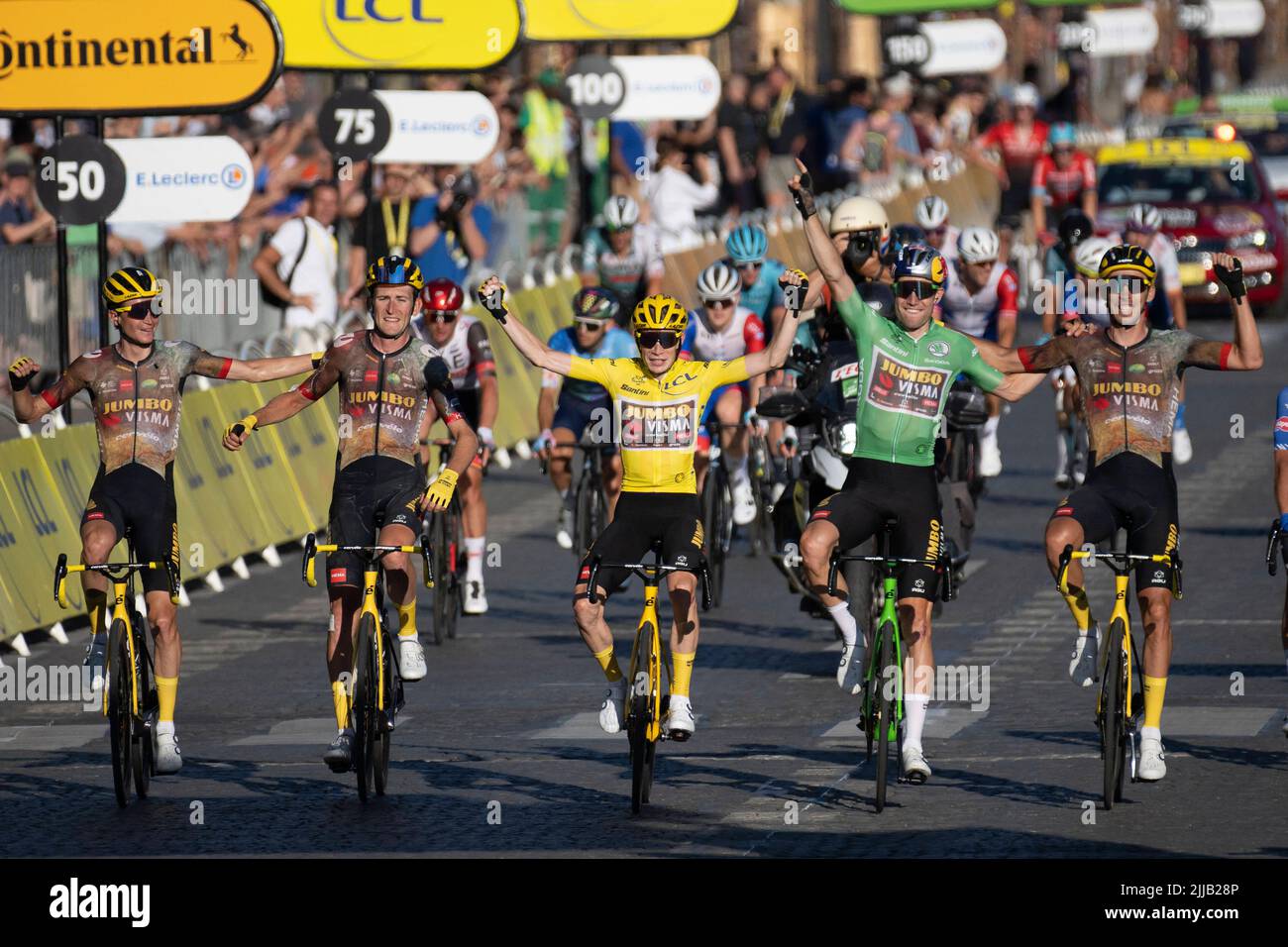 Paris, France, 24/07/2022, Jumbo-Visma teamDanish rider Jonas Vingegaard  wearing the overall leader's yellow jersey (2-L)celebrates flanked by his  teammate Jumbo-Visma team's Belgian rider Wout Van Aert (2-R) wearing the  sprinter's green jersey