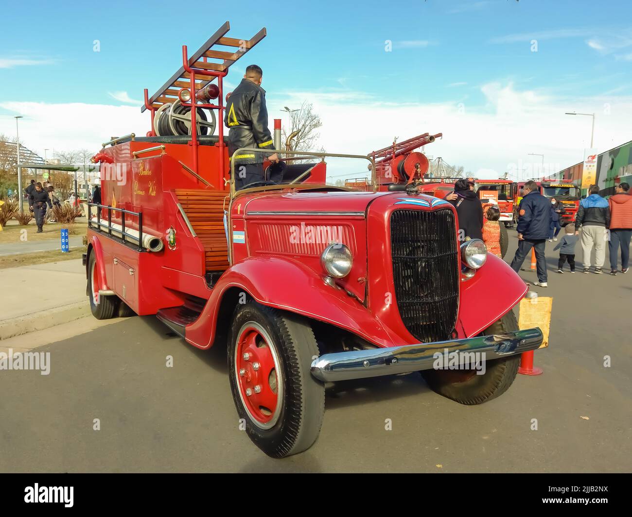 Old red 1936 Ford model 51 V8 fire truck pumper tanker. Front view. Grille. Ladder. Classic car show. Stock Photo