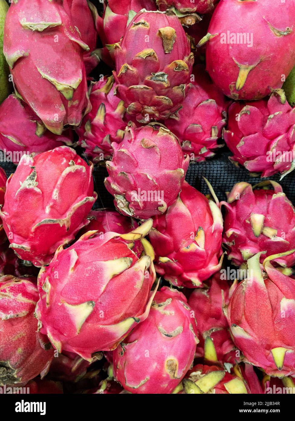 Red dragon fruits in pile on shop tray background Stock Photo