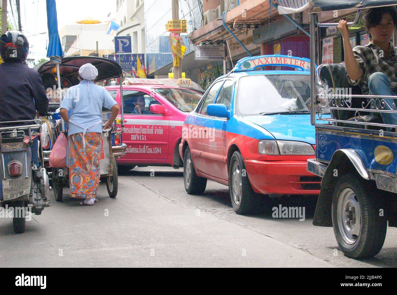 Bangkok Thailand August 10 2007; Taxi, cars, tuktuk and woman pushing