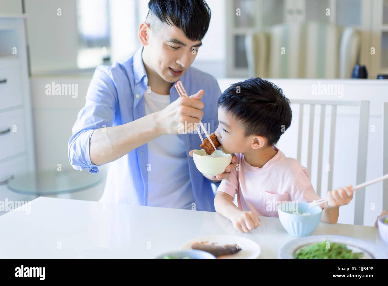 Happy father and son having dinner at home Stock Photo
