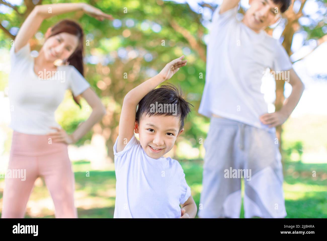 Happy family life. Kid and parents  having Fun with sport day at outdoors. Stock Photo