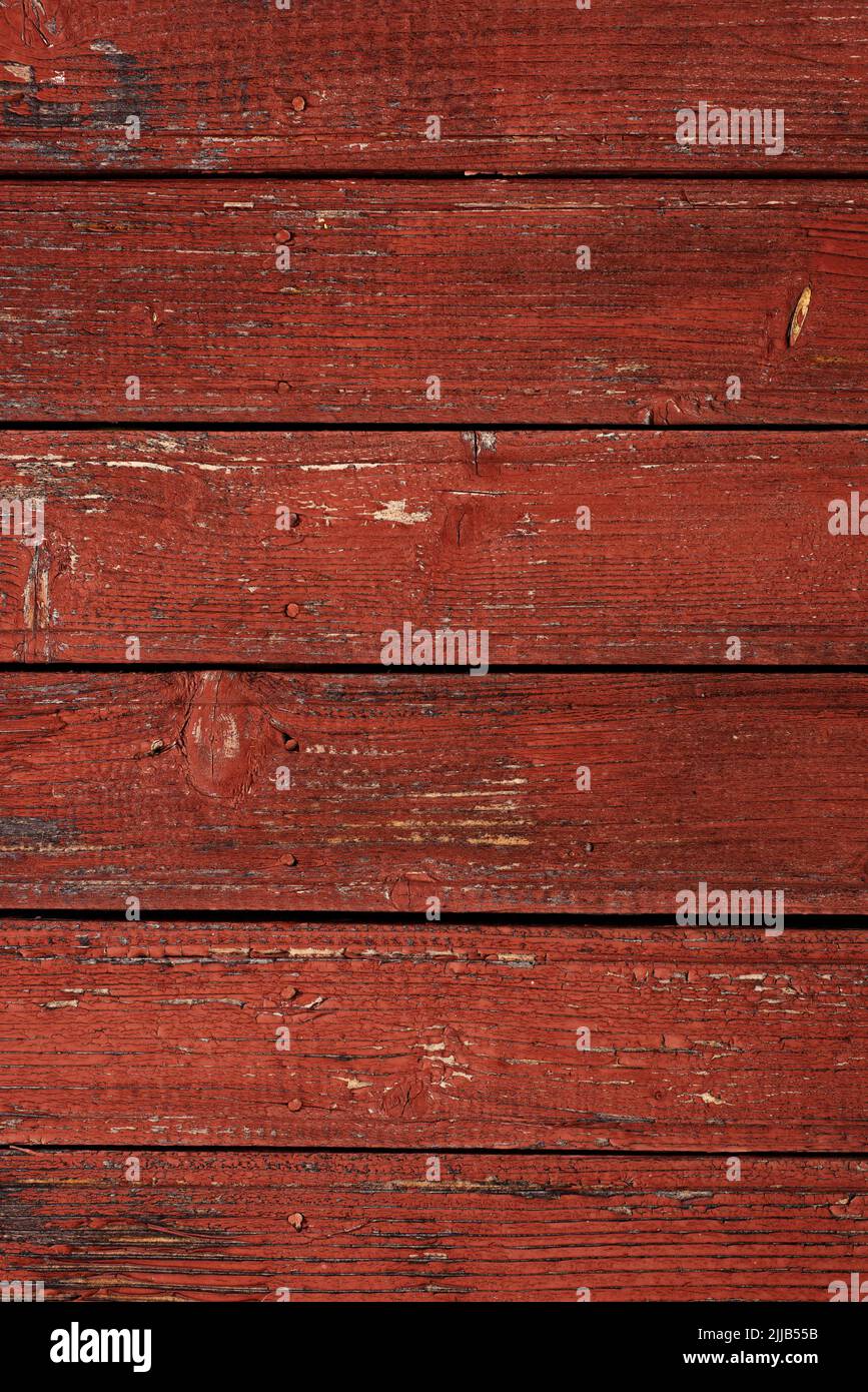 Old natural weathered wooden planks with cracked red paint background Stock Photo
