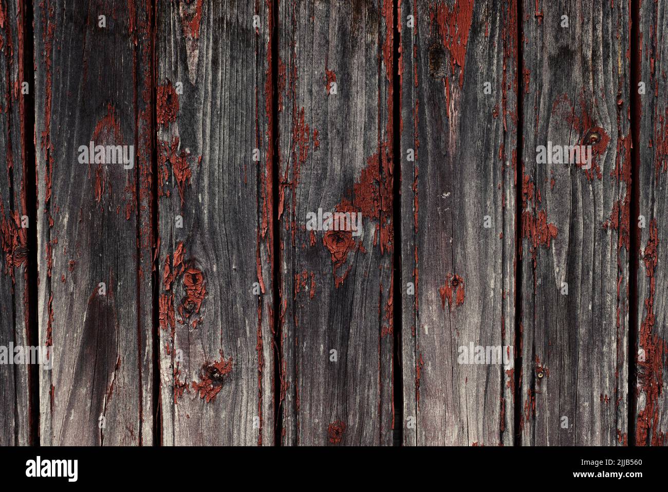 Old natural weathered wooden planks with cracked red paint background Stock Photo