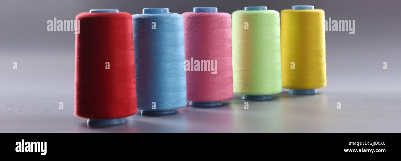 Fabric threads of different colors on gray background Stock Photo