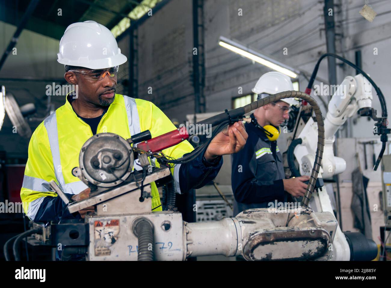 Factory workers working with adept robotic arm in a . Industry
