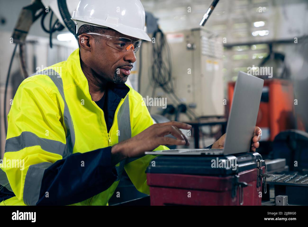 Factory worker working with laptop computer to do adept procedure