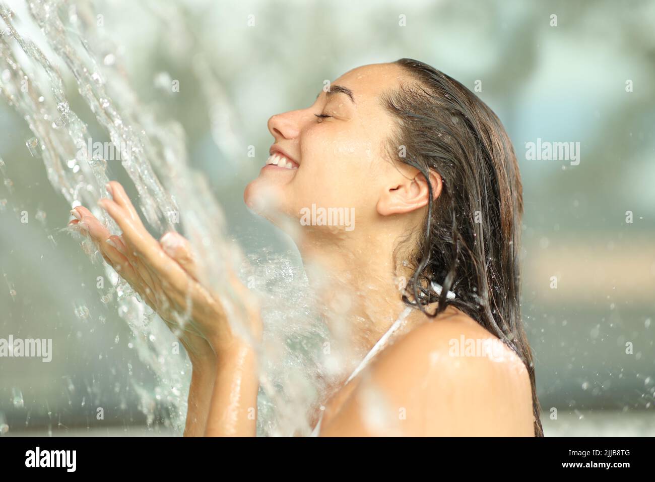 Profile of a happy woman enjoying of water jet in spa Stock Photo