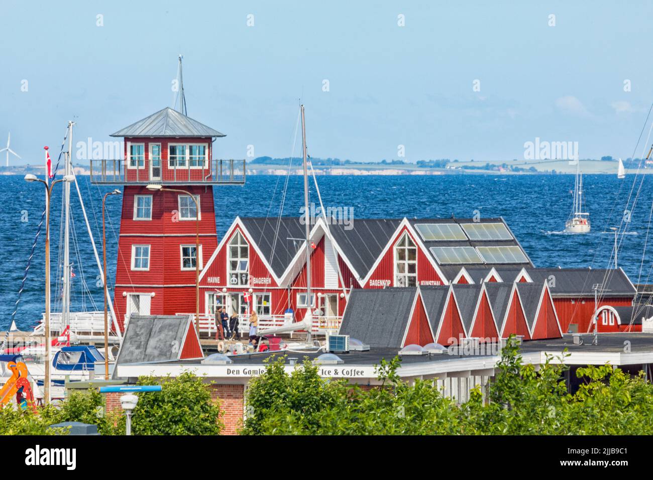 Bagenkop, Denmark – June 16, 2022: Commercial buildings and lookout tower at the harbor of Bagenkop, Langeland, Denmark. Island of Ærø in background Stock Photo
