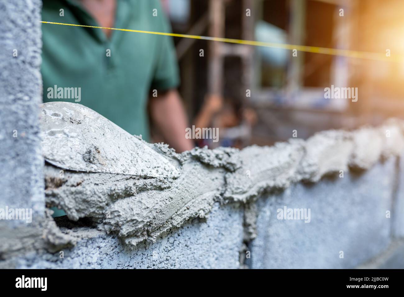 Workers use trowels to construct walls or walls with bricks and mortar. Stock Photo