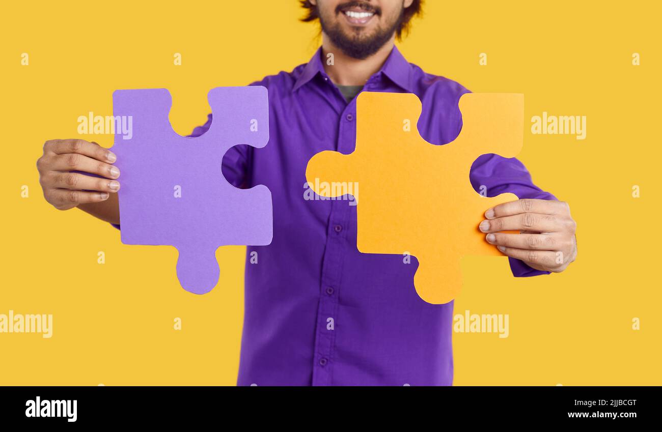 Two big puzzle pieces in hands of man symbolize building of cohesive team for company and business Stock Photo