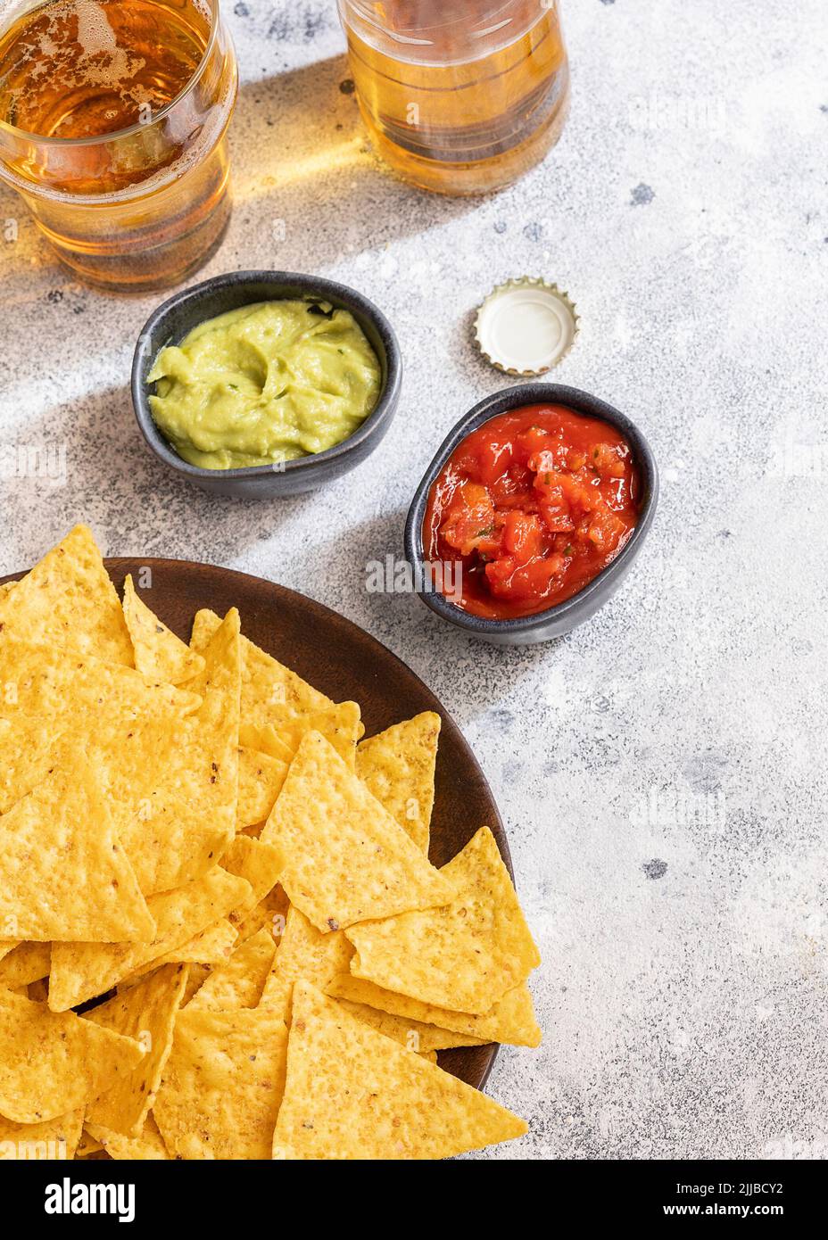 Famous Mexican snack, nachos with guacamole, red chilli sauce and beer