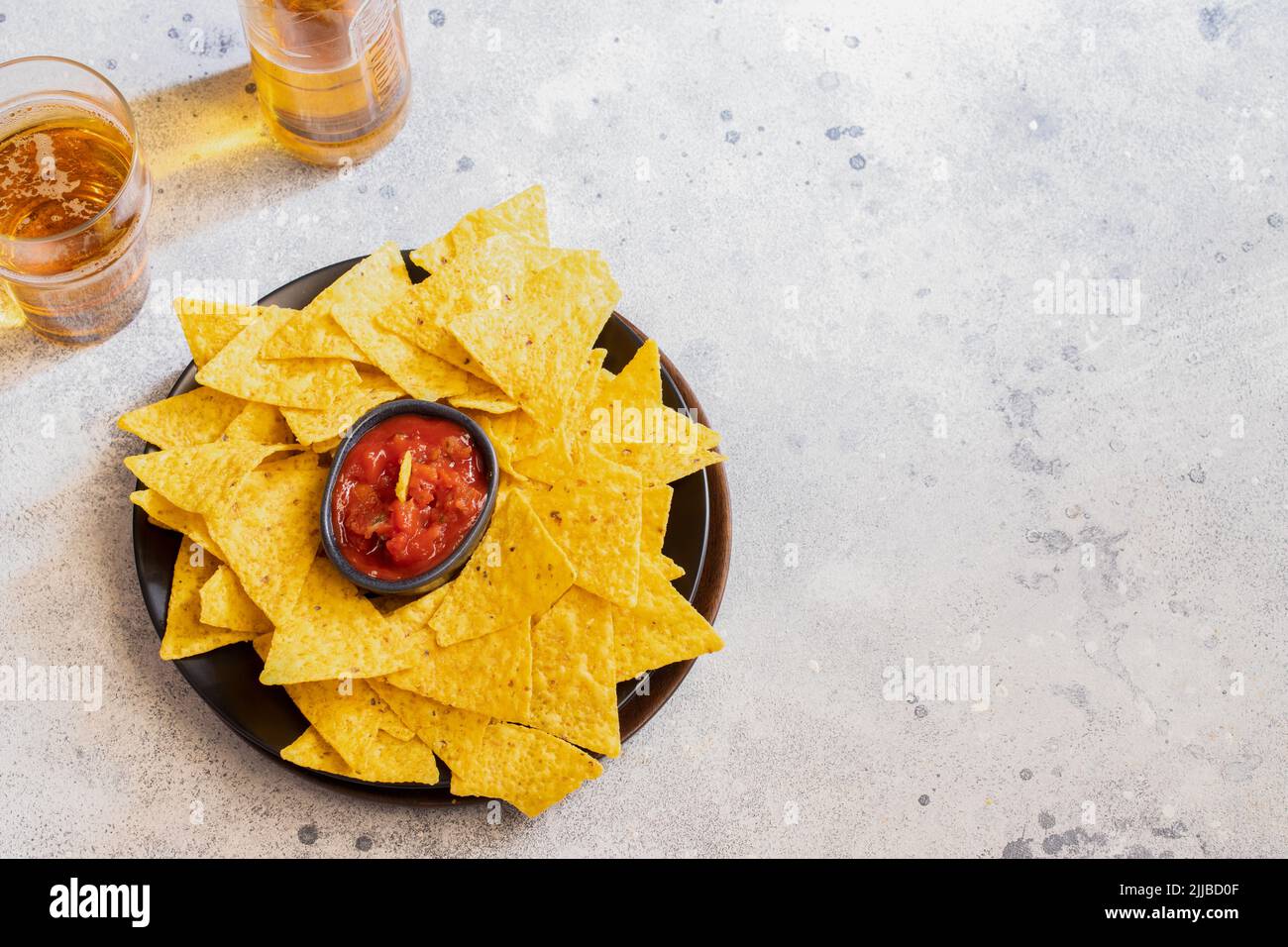 Famous Mexican snack, nachos with guacamole, red chilli sauce and beer