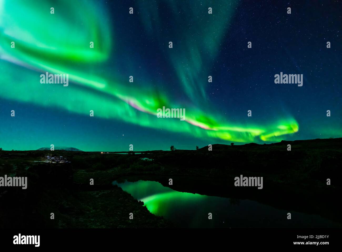 Northern lights with dark water canal and green reflections Stock Photo