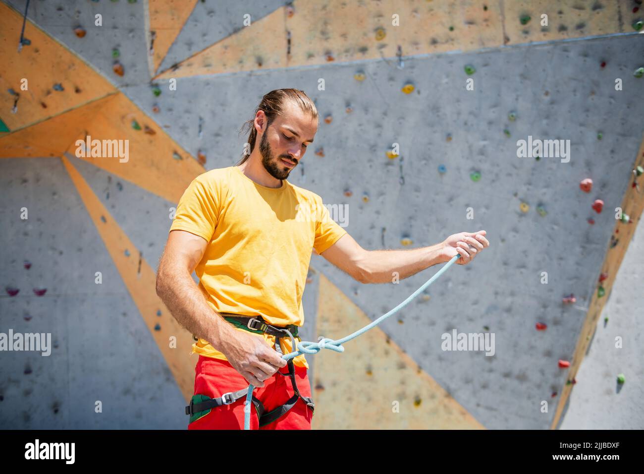 Sportsman climber prepares to climb a climbing route, climbing on