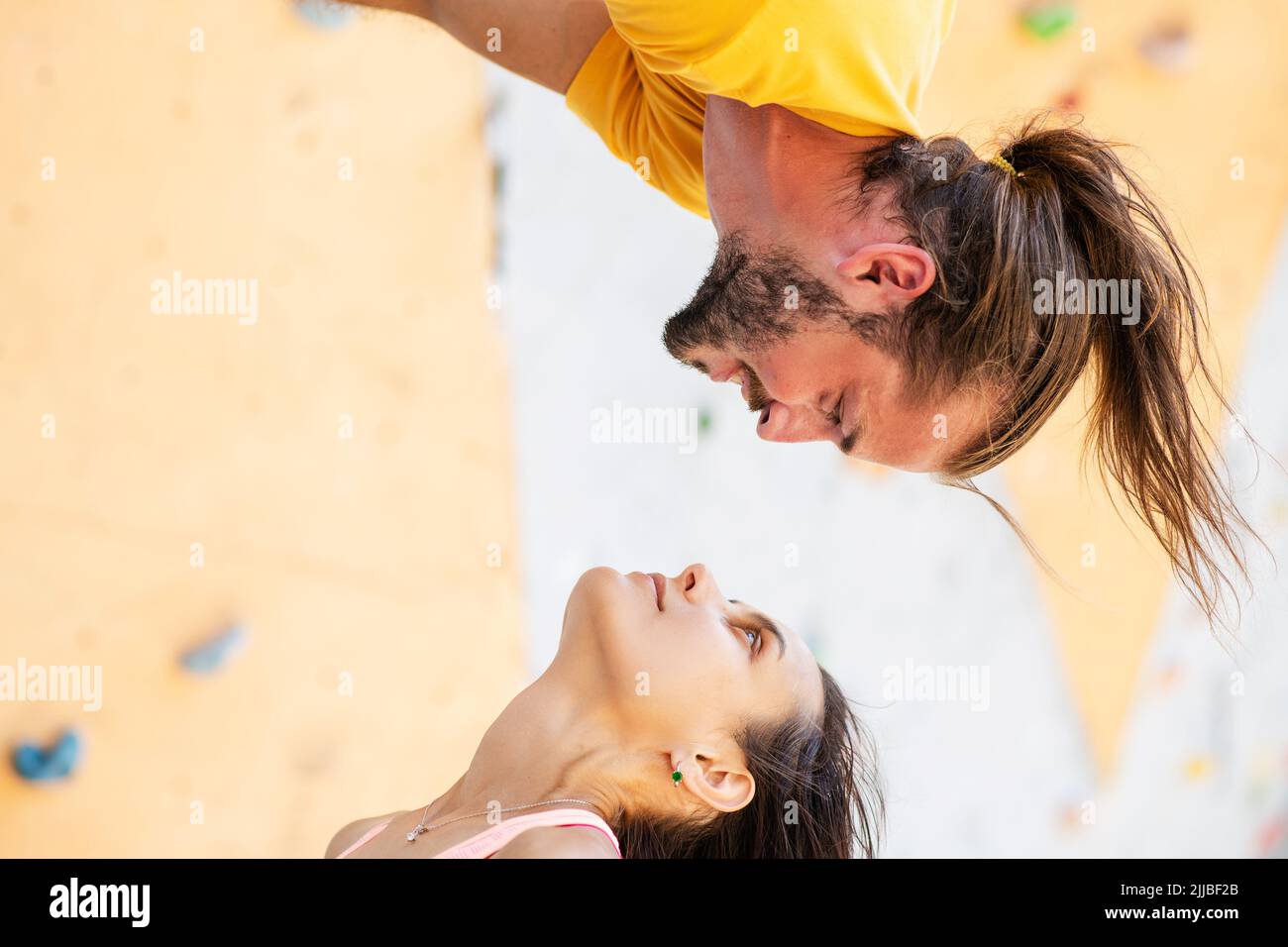 Man and woman on the background of an artificial climbing wall. The man ...
