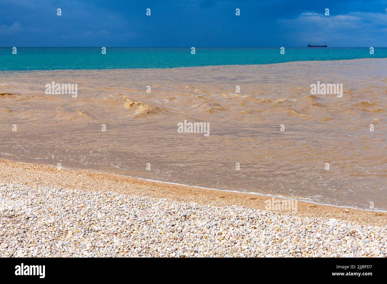 Muddy water of Belbek river mixed with blue seawater near an empty beach coast. Summer seascape, Crimea Stock Photo